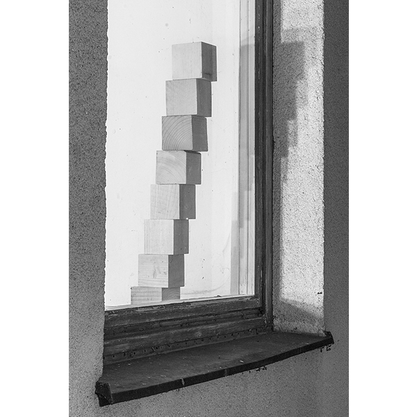 PETER PUKLUS<br/>0750 Eight wooden blocks arranged to form a stairway behind a window, 2014, analogue print on baryta-paper<br/>36 x 24,7 cm, ed. 5